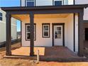 The covered patio has craftsman style columns, fresh concrete, and a rear door entrance to the home at 2108 Boxwood Circle Se, Conyers, GA 30094