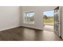 Bright empty room with dark wood floors and large window showing neighborhood view at 4075 Newburn Ct, Cumming, GA 30028