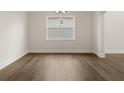 Neutral empty room featuring hardwood floors, modern lighting, and white trim at 4075 Newburn Ct, Cumming, GA 30028