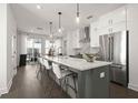 A modern kitchen featuring white cabinets, stainless steel appliances, and a large island with seating at 201 New St # 1102-8, Decatur, GA 30030