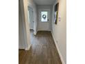 Bright hallway featuring wood-look floors, white walls, and views of the front door at 746 Great Oak Pl, Villa Rica, GA 30180