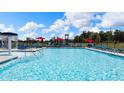 Resort-style community pool view, including a splash fountain, lounge chairs, umbrellas, and a playground at 165 Aster Avenue, Locust Grove, GA 30248