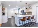 Modern kitchen featuring a breakfast bar with leather stools, sleek white cabinetry, and stainless steel appliances at 3020 Norton Se Ct, Smyrna, GA 30082