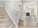 Inviting staircase with view of living room with fireplace and hardwood floors at 674 Sundial Ln, Mableton, GA 30126