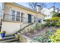 Inviting brick home featuring a black front door, black railings, and low maintenance yard at 231 Peachtree Ne Way, Atlanta, GA 30305