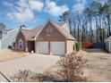 Brick home featuring a two-car garage, complemented by a well-maintained lawn at 2701 Garland Way Way, Duluth, GA 30096