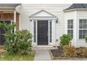 A beautiful entryway with a black door, manicured plants, and a clean walkway at 32 Hampton Dr, Cartersville, GA 30121