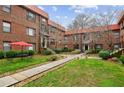 Multi-unit brick building with tile roof, lush courtyard with green grass and walkway at 694 Argonne Ne Ave # 4, Atlanta, GA 30308
