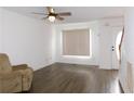 Living room with hardwood floors, a ceiling fan, a front door, and a large window at 554 Samaritan Dr, Cumming, GA 30040