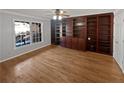 Bright living room featuring a large built-in bookcase, and hardwood floors at 2375 Muirfield Way, Duluth, GA 30096
