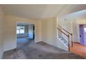Spacious living room with staircase, carpeted floor, view into the dining area, and natural light at 7402 Gossamer St, Union City, GA 30291