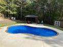 Backyard features a sparkling swimming pool with a tanning ledge and a gazebo with outdoor seating at 320 Red Fox Dr, Canton, GA 30114