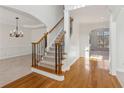 Bright foyer featuring hardwood floors, elegant staircase with iron spindles, and neutral decor at 3690 Millwater Xing, Dacula, GA 30019