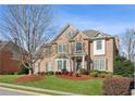 Charming brick home with manicured landscaping, lush green lawn and mature trees creating curb appeal at 3690 Millwater Xing, Dacula, GA 30019