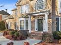 Inviting front porch with brick steps, decorative columns, and a stylish front door with a wreath at 3690 Millwater Xing, Dacula, GA 30019