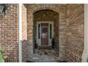 Inviting stone-arched porch and doorway with beautiful stone and brick accents at 4880 Cecilia Sq, Cumming, GA 30040