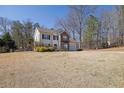 Charming home featuring a brick and siding exterior, attached garage, and a well-landscaped front yard with mature trees at 420 Sanford Creek Ln, Lawrenceville, GA 30045