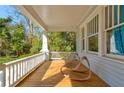 Inviting covered front porch with hardwood floors, rocking chairs, and white railings offering peaceful outdoor space at 565 Candler St, Atlanta, GA 30307