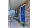 Charming front porch featuring stone accents, a cozy seating area, and a vibrant blue front door at 5990 Mountain Top Pl, Cumming, GA 30041