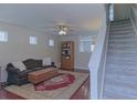 Comfortable living room with hardwood floors, staircase, and lots of natural light streaming through the windows at 5990 Mountain Top Pl, Cumming, GA 30041