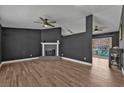 Open living room features hardwood floors, ceiling fans, and brick fireplace at 10330 Wisteria Ln, Jonesboro, GA 30238