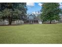 Spacious front lawn showcasing a charming home with a covered porch framed by mature trees at 2820 Maxwell Pl, Lithia Springs, GA 30122