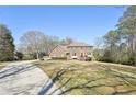 Stately brick home with green shutters, complemented by a long driveway and lush front lawn at 4805 Mystere Sw Ln, Lilburn, GA 30047