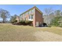 Side view of a brick home showing a garage and landscaped garden at 4805 Mystere Sw Ln, Lilburn, GA 30047
