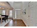 Bright and airy foyer with hardwood floors and a chandelier, leading to dining and living areas at 1635 Vinery Ave, Cumming, GA 30041