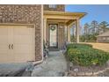 Inviting home entrance adorned with a wreath, features a well-maintained lawn, landscaping, and a cozy front porch at 3362 Brockenhurst Dr, Buford, GA 30519