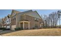 Charming brick townhome featuring a covered porch and lush lawn at 3362 Brockenhurst Dr, Buford, GA 30519