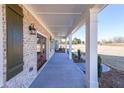 Inviting covered porch with brick accents, white columns, and a view of the expansive front yard at 5410 Crow Dr, Cumming, GA 30041