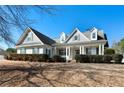 Traditional home showcasing a symmetrical facade, dormer windows, and a neatly landscaped front yard at 155 Rose Creek Dr, Covington, GA 30014