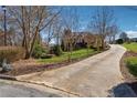 Long driveway leading to a brick home surrounded by mature trees and landscaping at 2850 Brandy Ln, Cumming, GA 30041
