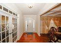 Inviting home foyer featuring hardwood floors and decorative glass french doors at 4594 Marching Ln, Fairburn, GA 30213