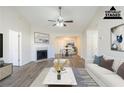 Bright, staged living room boasts hardwood floors, fireplace, ceiling fan, and an open floor plan at 11139 Silver Aspen Ct, Hampton, GA 30228