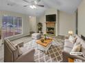 Inviting living room with a cozy fireplace, plush seating, and large windows at 29 Saint James Pl, Sharpsburg, GA 30277