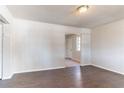 Bright living room with dark wood-look floors, fresh white paint and an open doorway leading to the kitchen area at 4051 Ester Sw Dr, Atlanta, GA 30331
