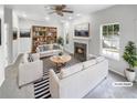 Bright, virtually staged living room with modern furnishings, fireplace, a ceiling fan, and large windows for natural light at 4565 Bridle Point Pkwy, Snellville, GA 30039