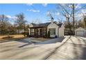 Exterior of home featuring a long driveway and a detached garage, surrounded by mature trees at 6687 Florence Dr, Lithia Springs, GA 30122
