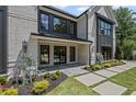 Beautiful exterior detail with modern black trim, stone tile porch, and professional landscaping at 372 Karen Dr, Alpharetta, GA 30009