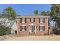 Beautiful brick home featuring a classic design with black shutters, a green door, and a well-maintained lawn at 1030 Eulalia Ne Rd, Atlanta, GA 30319