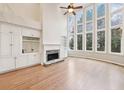 Elegant living room with built-in cabinets, fireplace, hardwood floors, and large windows at 1884 Point River Dr, Duluth, GA 30097