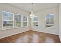 Bright dining room featuring a modern chandelier and large windows offering plenty of natural light at 3891 Shelleydale Dr, Powder Springs, GA 30127