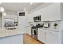 Modern kitchen featuring white cabinetry, stainless steel appliances, and granite countertops at 3891 Shelleydale Dr, Powder Springs, GA 30127