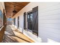 Inviting covered porch showcasing wooden decking, dark shutters, and a cozy outdoor ambiance at 210 Joe Green Ln, Canton, GA 30114