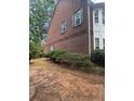 Side view of a brick townhome featuring mature trees and a well-manicured lawn at 3851 Guilderoy Ln # 1, Austell, GA 30106