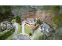 An aerial view shows a beautifully landscaped property nestled amongst mature trees at 4000 Rockingham Dr, Roswell, GA 30075