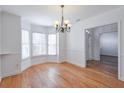 Light-filled dining room with hardwood floors, white walls, and a chandelier at 893 Lance Cir, Lawrenceville, GA 30043