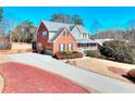 Well-manicured lawn with driveway leading to a brick home with covered porch at 3064 Zermatt Way, Snellville, GA 30078